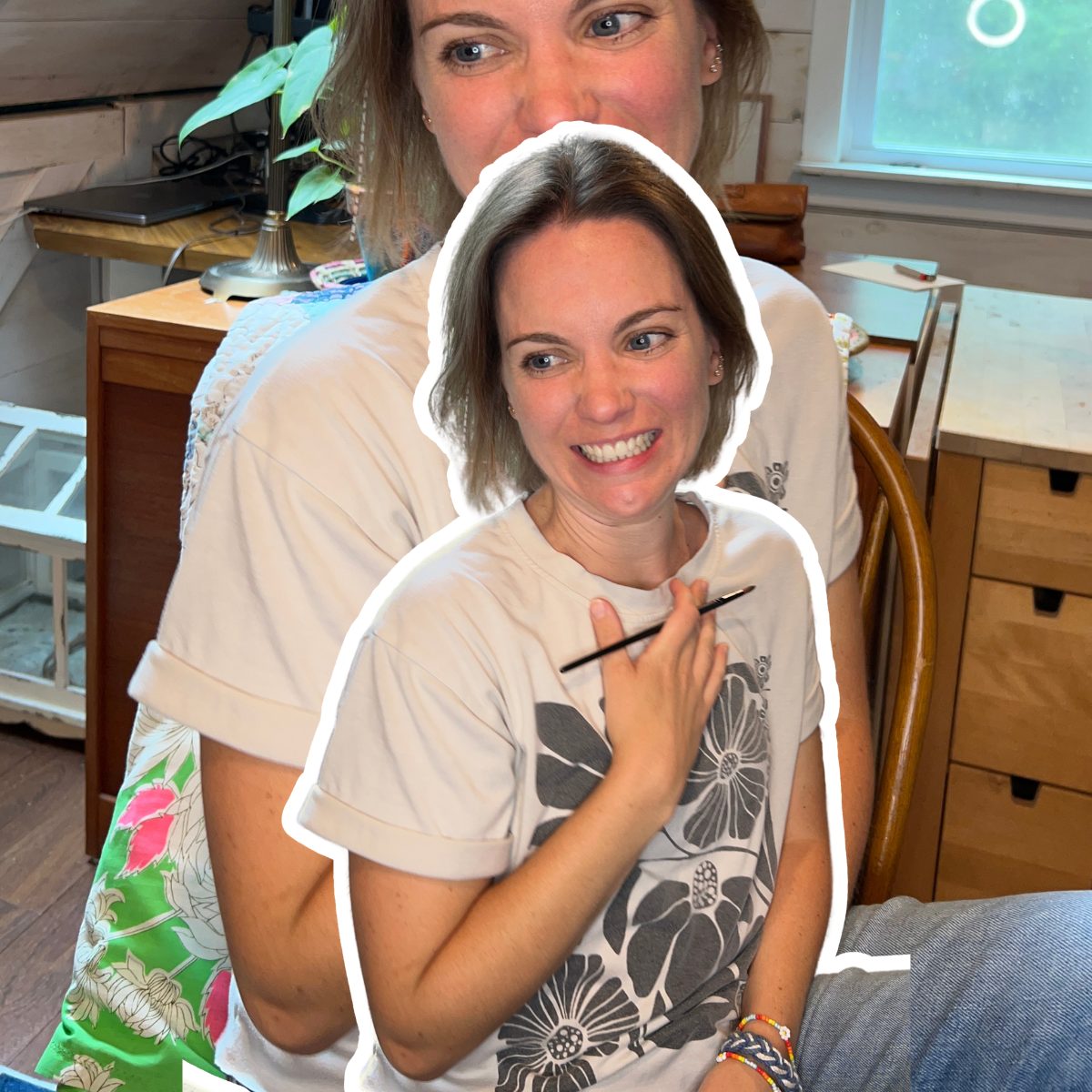 Alli, the spiritual marker artist behind x0alli, smiling in her home studio holding a paintbrush