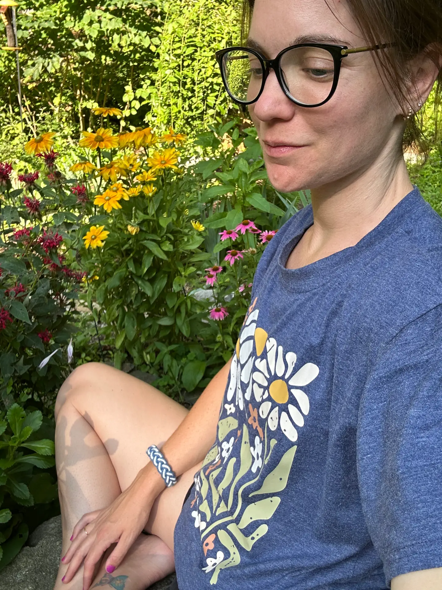 Alli in the garden among flowers and greenery