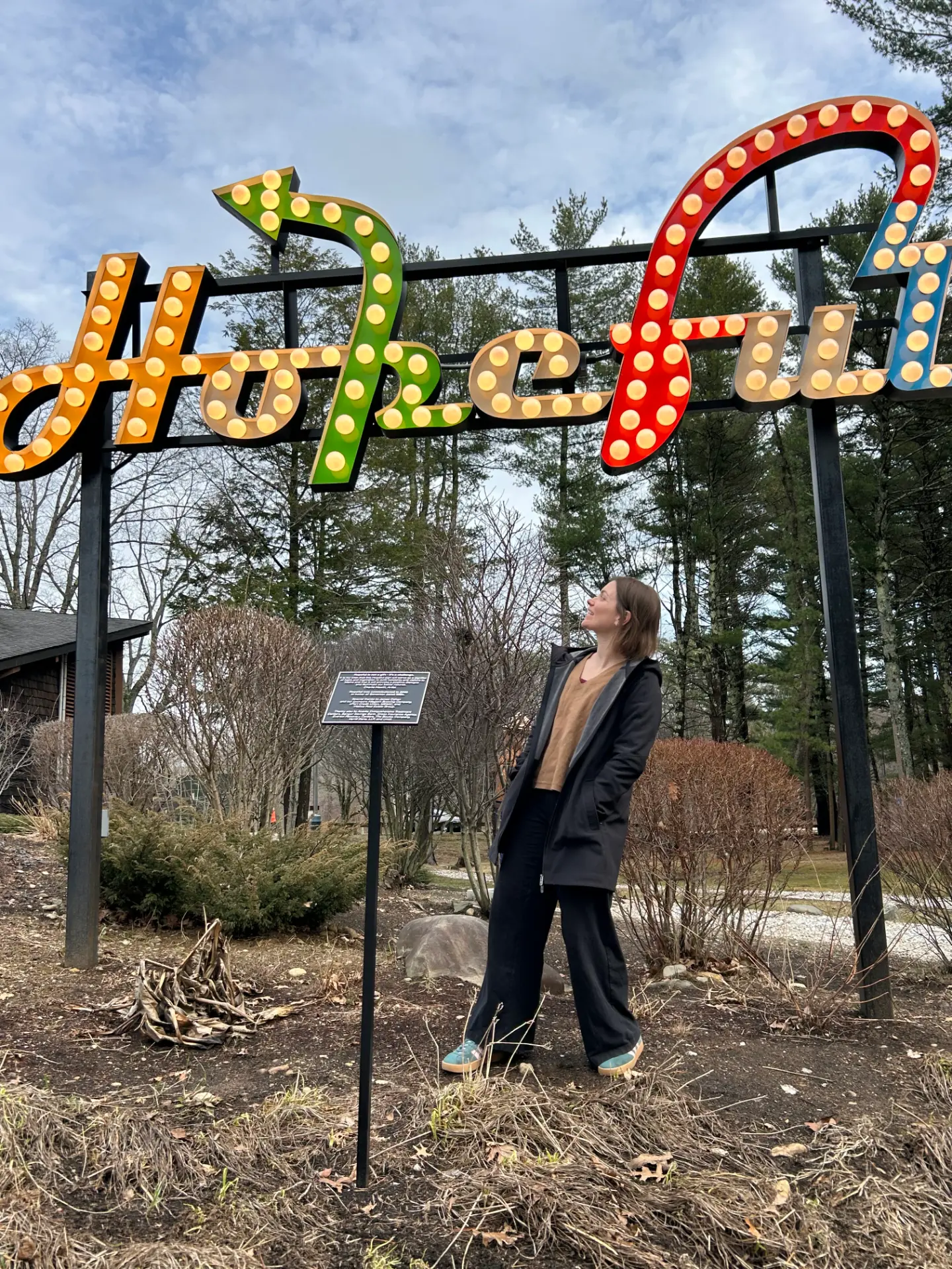 Alli standing under a large colorful Hopeful sign